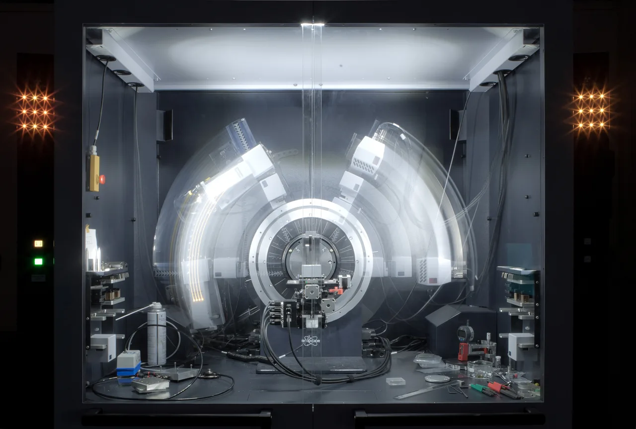 X-ray diffractometer captured in motion during a long exposure, producing overlapping radial arcs